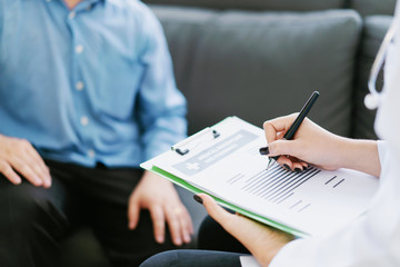Asian female Doctor and patient are discussing something ,Having Consultation,Medical physician working in hospital writing a prescription, Healthcare and medically concept,selective focus