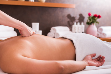 Obraz na płótnie Canvas Man enjoying sports massage at spa