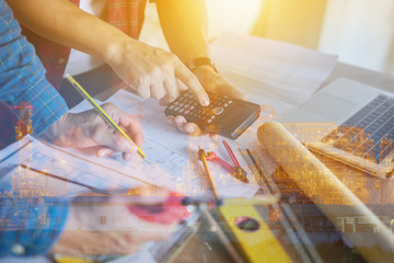 architect man working with laptop and blueprints, architectural plan with calculator in loft office,Building Design,Home or house town planning,engineering tool for sketching a construction project