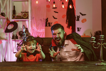 Happy family scares everyone for Halloween. Father and son have fun at a home party in October. Happy childhood with parents, holidays.