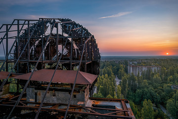 Soviet Union iron coat of arms in the dawn rays on the roof of a multi-storey building in an...