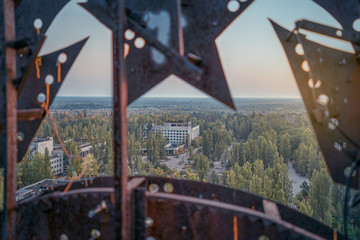 Soviet Union iron coat of arms in the dawn rays on the roof of a multi-storey building in an...
