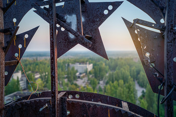 Soviet Union iron coat of arms in the dawn rays on the roof of a multi-storey building in an...