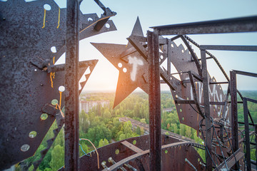 Soviet Union iron coat of arms in the dawn rays on the roof of a multi-storey building in an...