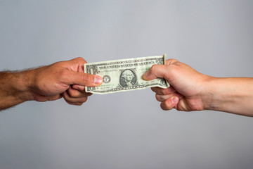 Two hands holding dollar bill. People fighting over money. Financial conflict concept