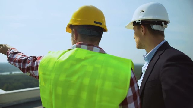Construction foreman talking to contractor discussing project details outdoors