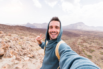 Happy hiker takes a selfie on the top of the mountain.