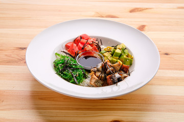 Unagi sashimi rice bowl with avocado, seawed, tomato and soy sauce