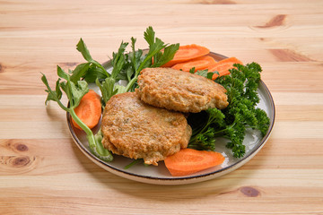 Fried beef cutlet in breading with fresh carrot
