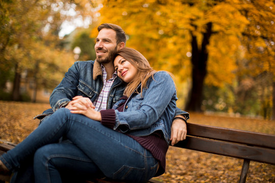 Young loving couple on a bench in autumn park