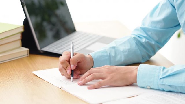 ノートに書く男性
