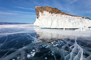 Baikal Lake at February sunny day. Blue smooth ice with bubbles and cracks near the beautiful iced...