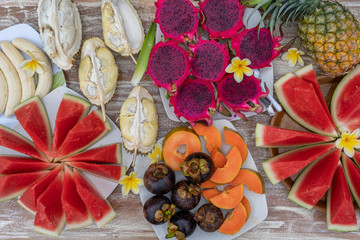 Tropical fruits assortment, closeup, top view. Many colorful ripe fruits background. Durian, papaya, watermelon, banana, mangosteen, pineapple and pitahaya or dragon fruit in island Bali, Indonesia
