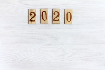 wooden plates with numbers on a light wooden background, top view. 2020 and a lot of empty space