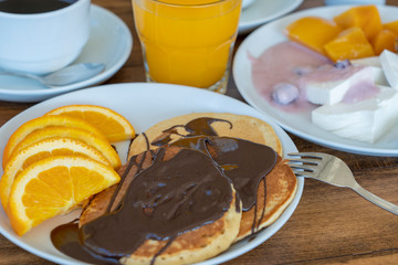 Breakfast of many dishes and drinks on a wooden table, closeup. Food concept