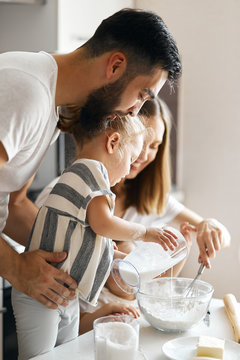 little girl pouring milk to pastry. close up side view photo.