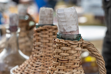 The stopper and the neck of a wicker bottle of wine in the background, closeup