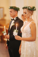 Beautiful couple in church. Newlyweds swear to each other to love forever. Happy bride and groom