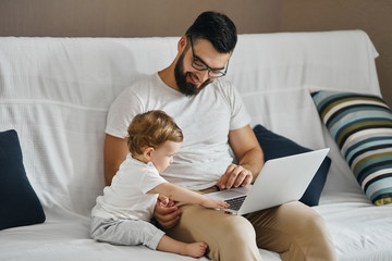 young smiling man in glasses teaching his kid to work on laptop, education, leisure, pastime , close up photo