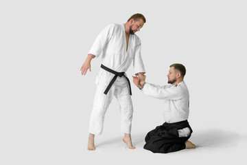 Two caucasian men are practicing aikido on the tatami (isolation path included)