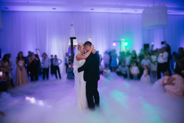 First dance of stylish wedding couple. Handsome groom and elegant bride in the restaurant