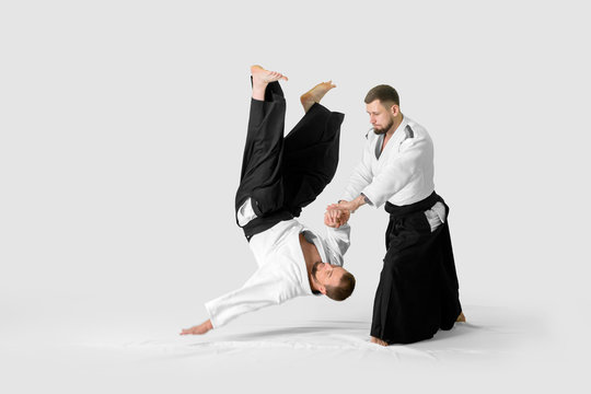 Two caucasian men are practicing aikido on the tatami (isolation path included)