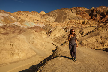 A hiker in the Artist`s Palette landmark place in Death Valley National Park, Geology, sand.