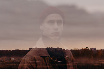 Multiple exposure. Traveler in a raincoat and a red knitted hat. Loneliness. Psychology