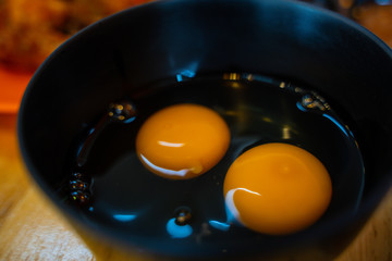 Yellow egg white and yolk baking ingredient in a black bowl