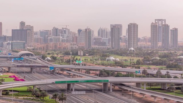 Dubai Golf Course with a cityscape of Gereens and tecom districts at the background aerial timelapse. Traffic on sheikh zayed road with junction and bridges