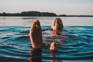 Fotobehang Finnish Girl in a Lake swimming, blue, Finland, summer © JohanSebastian