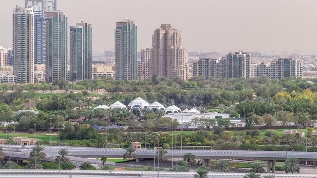 Dubai Golf Course with a cityscape of Gereens and tecom districts at the background aerial timelapse. Traffic on sheikh zayed road with junction