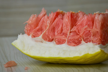 A closeup shot of a piece of a red pomelo.