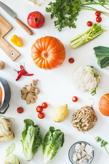 Healthy organic seasonal vegetables on white kitchen desktop with herbs and spices. Top view. Frame. Copy space. Vegetarian cooking and eating.  Local food. Blog layout. Pumpkin time.