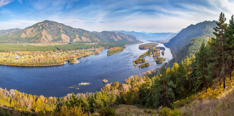 Naklejka na ściany i meble Autumn landscape. The Yenisei River flows through a picturesque valley. Blue water and islands. South of Western Siberia. 