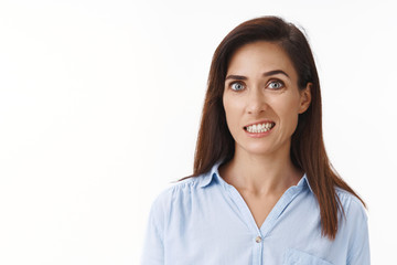 Embarrassed uncomfortable cute adult woman feeling pity guilty making mistake, clench teeth apologizing discomfort, stand white background distressed, feeling awkward and concerned show teeth