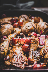 Fried chicken legs with red onion and grapes,close up