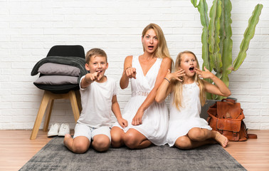 Mother with her two children at indoors pointing to the front