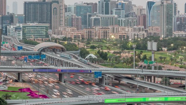 Dubai Golf Course with a cityscape of Gereens and tecom districts at the background aerial day to night transition timelapse. Traffic on sheikh zayed road with metro station