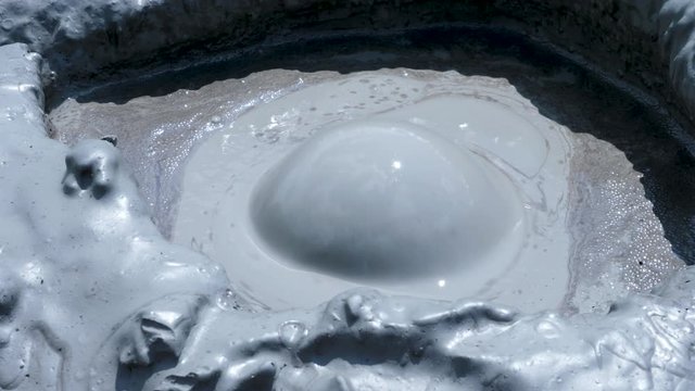 Close up shot of mud volcano gas eruption in hot summer day. Slow motion shot
