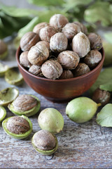 Inshell walnuts in a bowl. Harvest walnuts. The leaves of the walnut tree. Walnuts in a green peel. Selective focus. Macro.