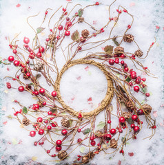 Christmas wreath with red berries on snow, top view. Frame. Copy space