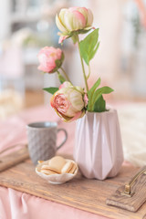  Tray with a romantic breakfast and rose (tea, cakes and a bouquet of peonies) in the bedroom in pastel colors