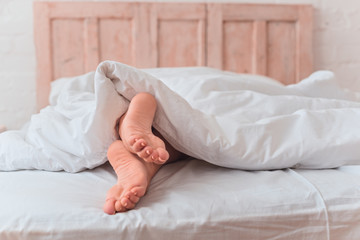 Alone female legs in bed