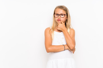 Fototapeta premium Little girl over isolated white wall having doubts