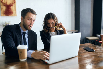 angry unhappy frustrated young people having problems in their company , firm.young man and woman has problem with internet, computer