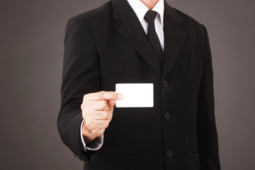 Man in suit holding white business card isolated on gray background