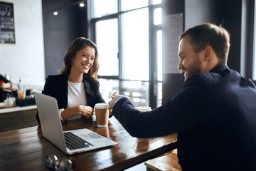 cheerful positive tatented business people concluding an agreement, signing a contract during the meeting. close up photo