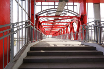 Long overpass over the road. Metal constructions. Red painted metal.