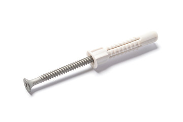 Plastic dowel and self-tapping screw on white background